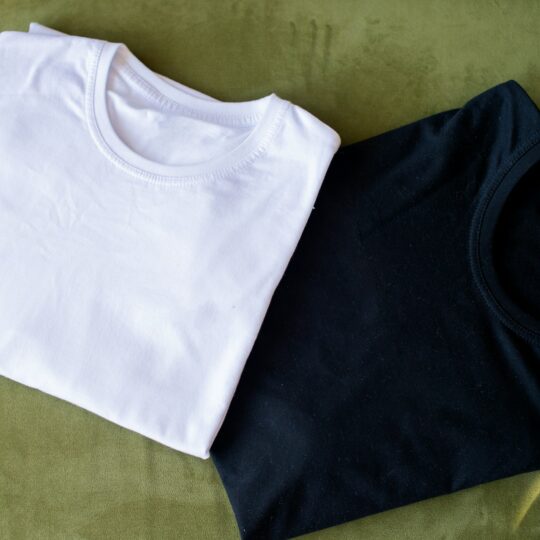 A black and white T-shirt lies folded on the table