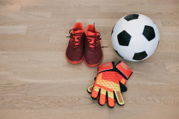 Goalkeeper gloves, soccer shoes and soccer ball ready for the game